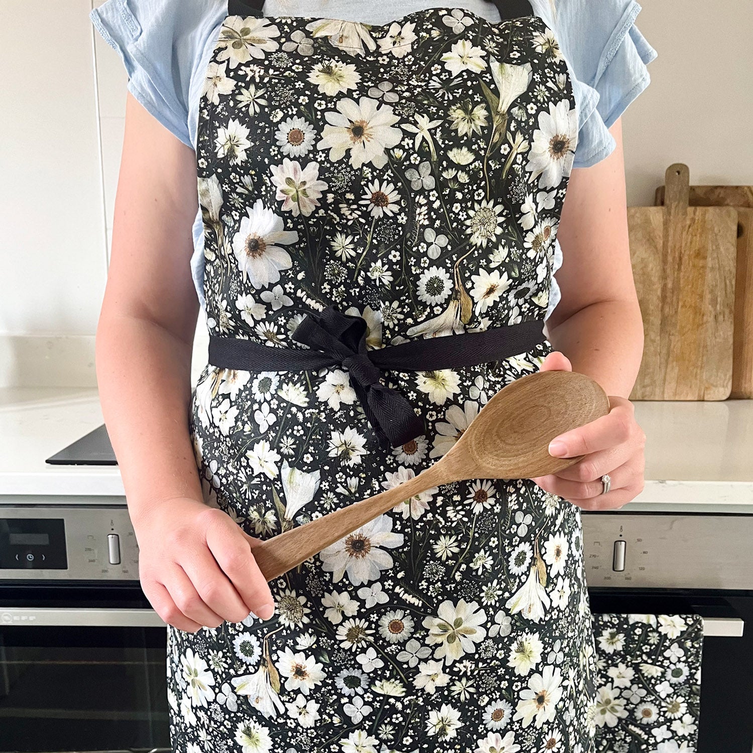 Floral Apron with a pressed flower design in black and white, with adjustable neck, and long black ties.