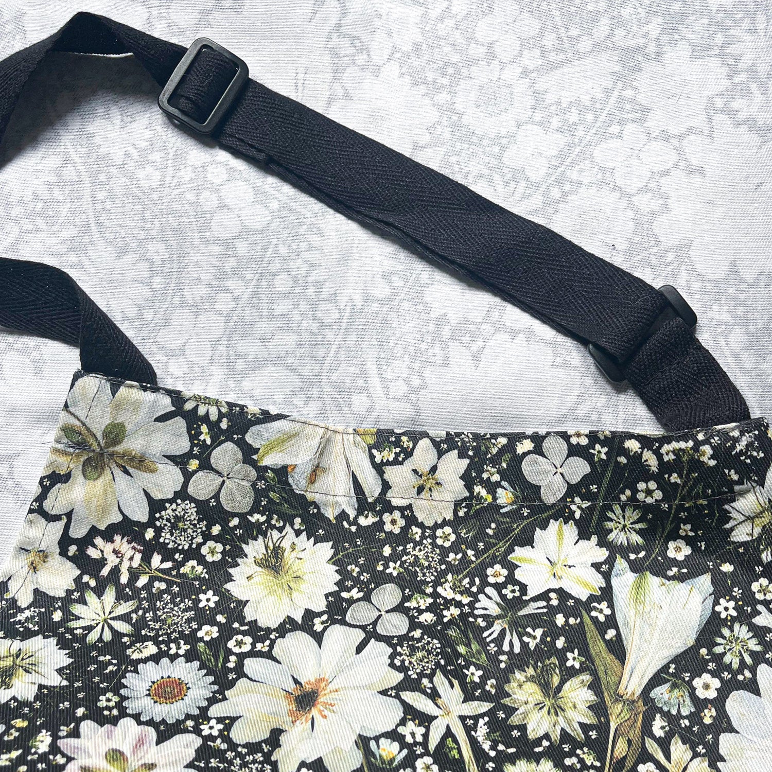 Adjustable neck full apron with a unique pressed flower design.