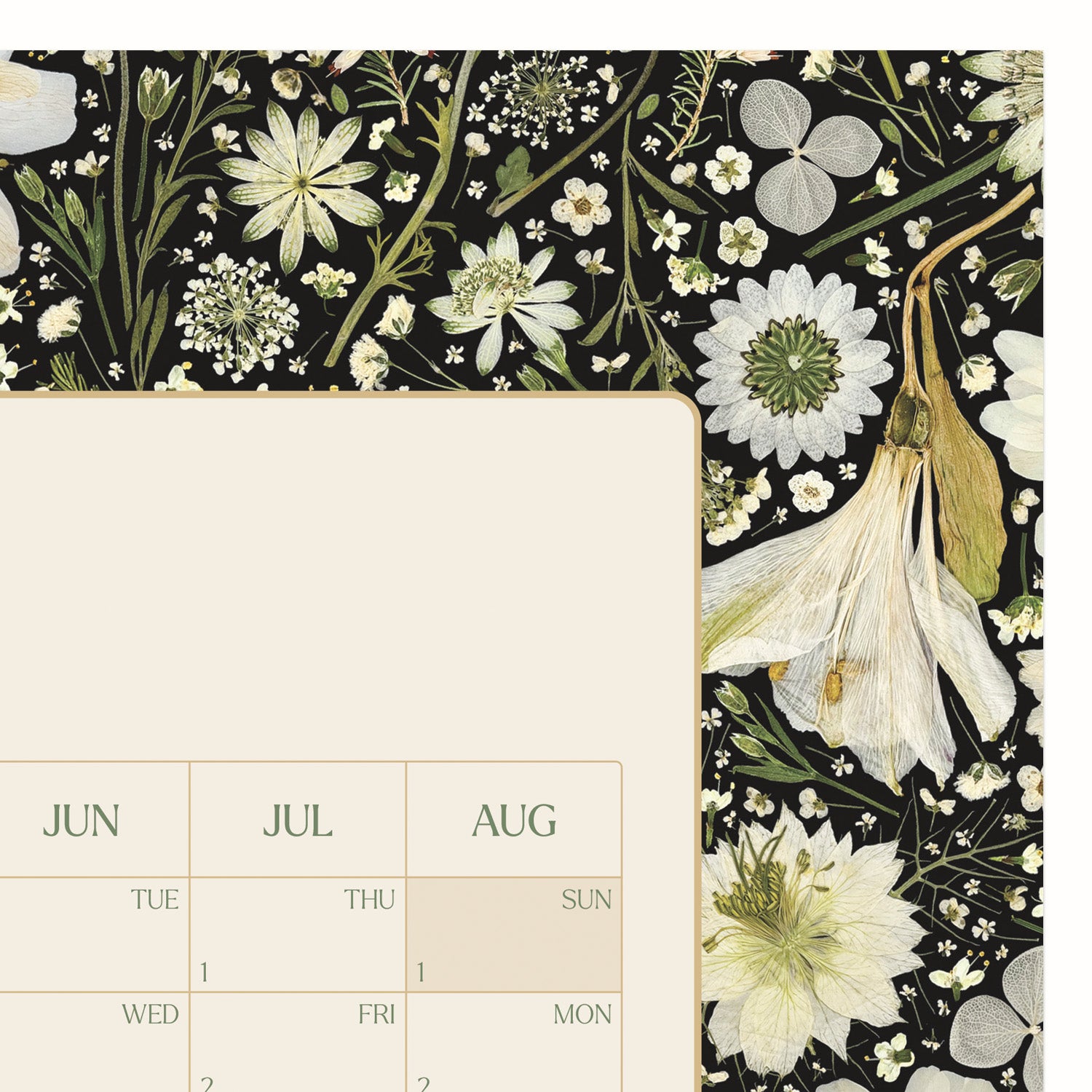 A close-up of a botanical planner with a black background and cream, white, and green floral pattern along the right side and top edge. The left side shows an off-white writing area with a monthly grid.
