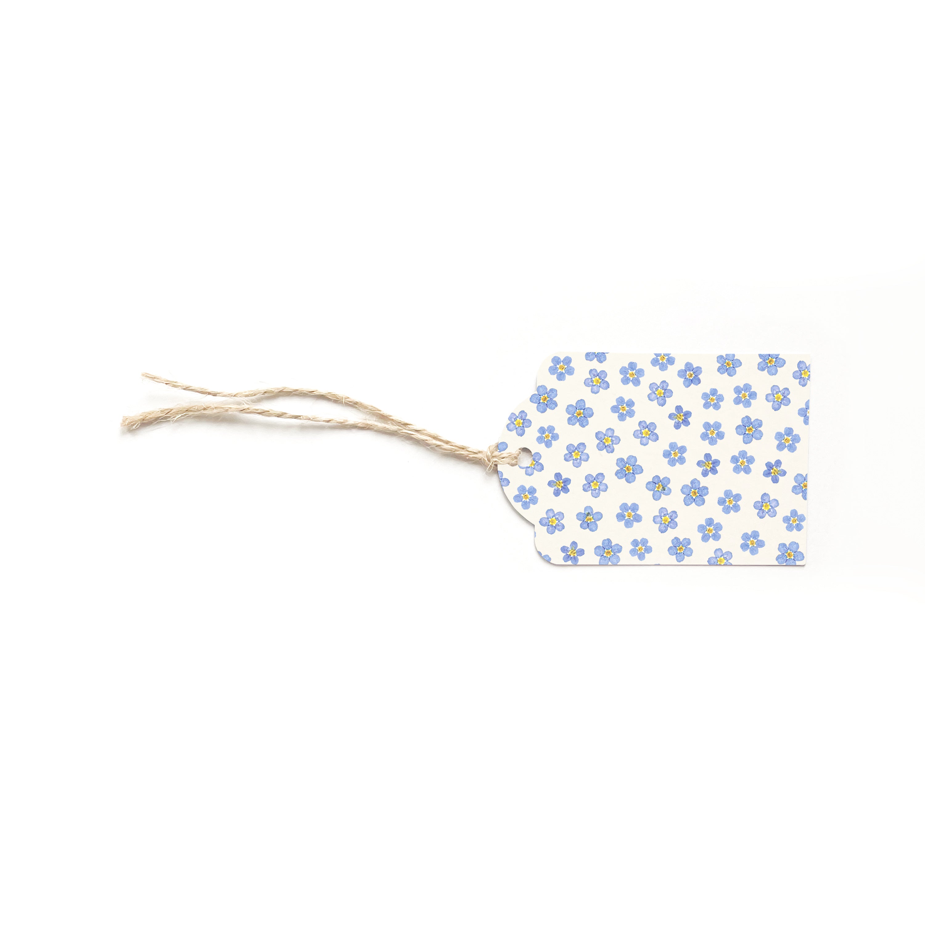 Gift tag with a pressed floral pattern made up from forget-me-not heads. Complete with brown twine.